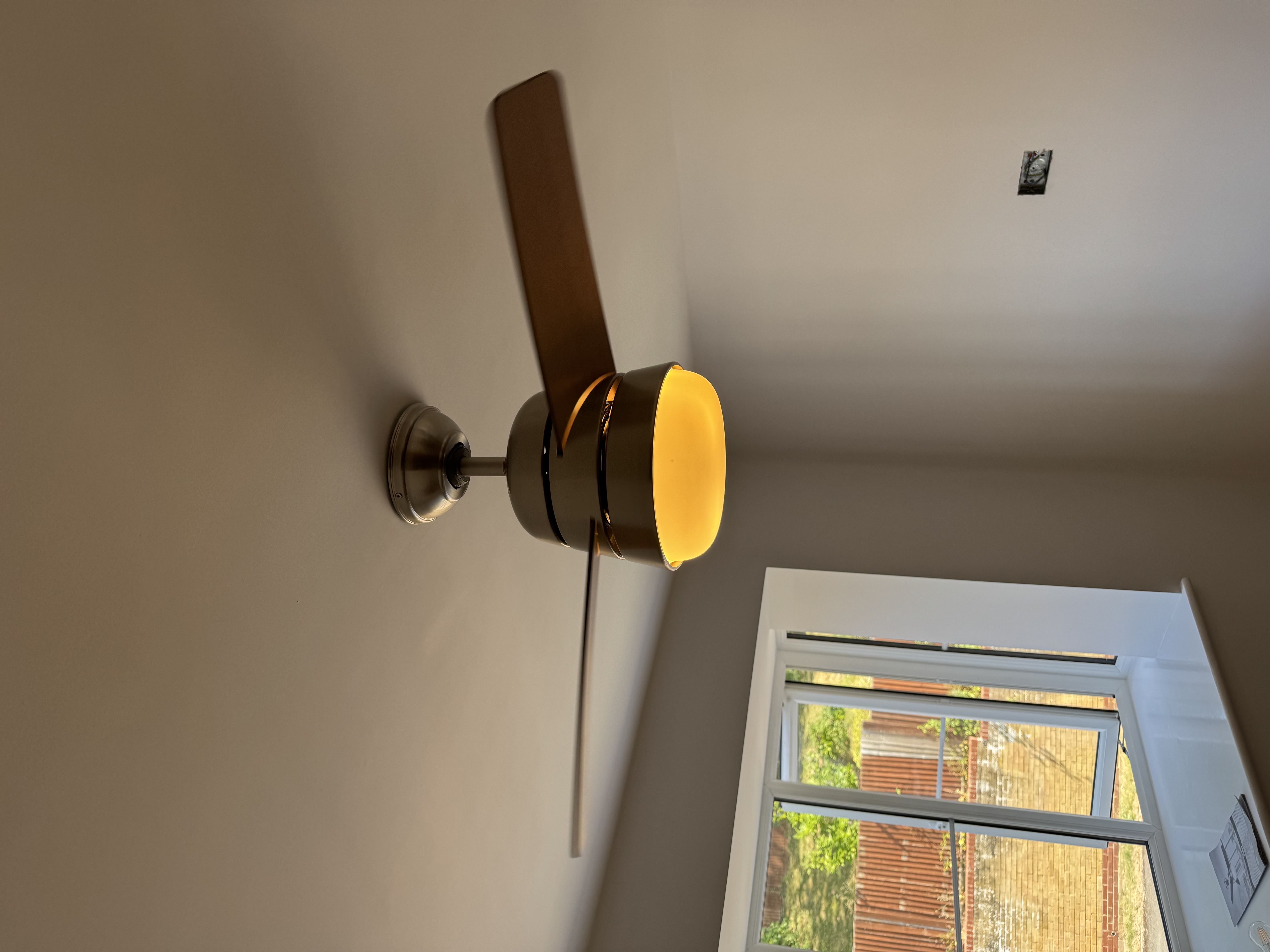 Electrician installing the new ceiling fan in place of the old pendant light