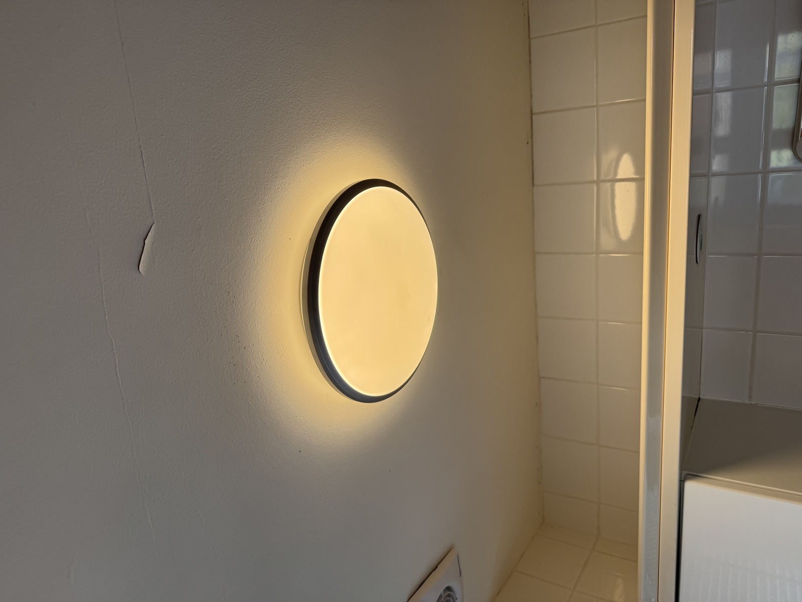 The new bathroom ceiling light fitted and working, giving a warm, even glow